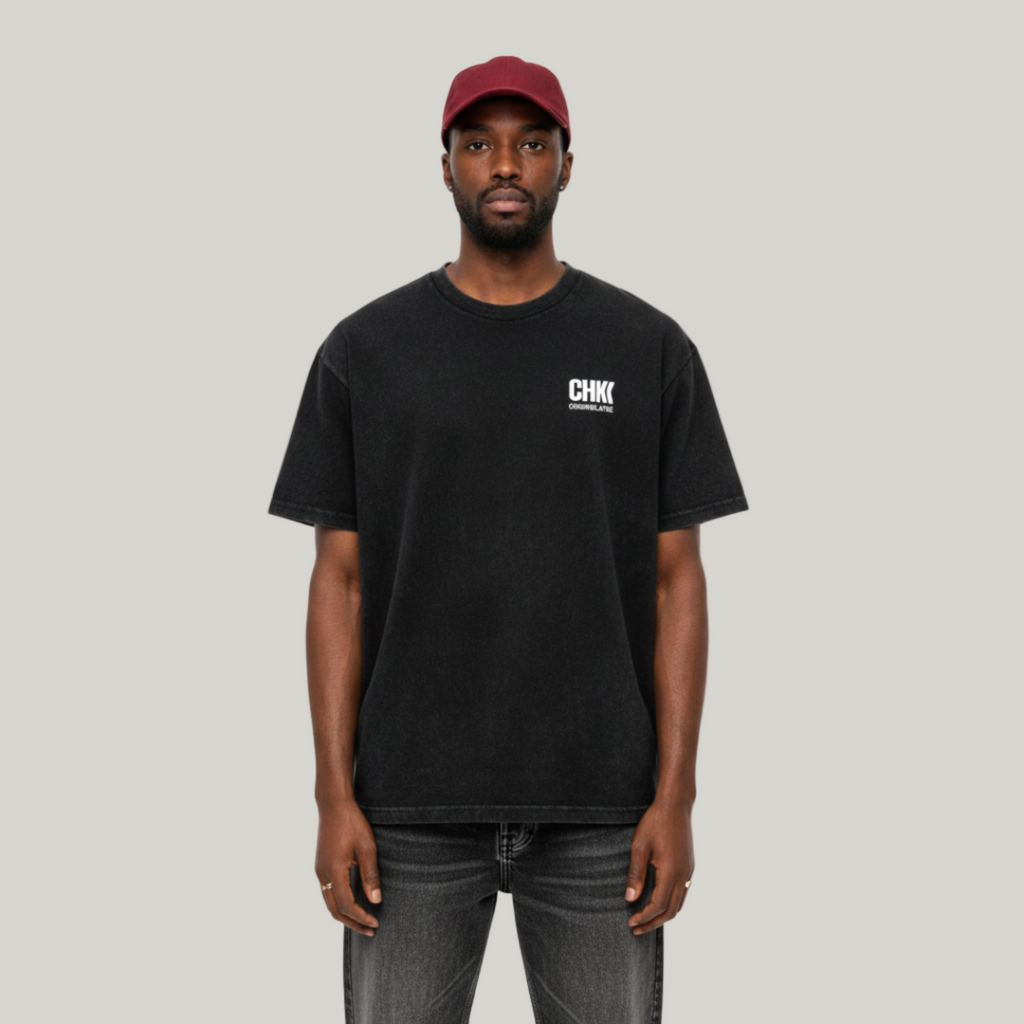 Person wearing a black t-shirt with a logo and a red cap on a white background